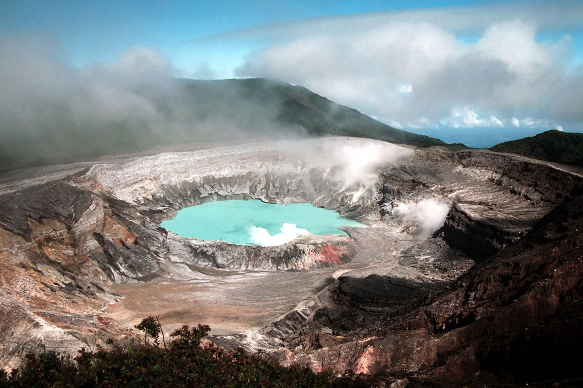 Clouds and steam hang around Poás Volcano’s crater pool.