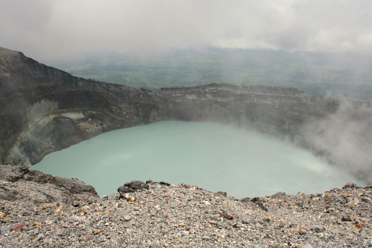 A crater filled with water on a grey day at Rincón de la Vieja Volcano.